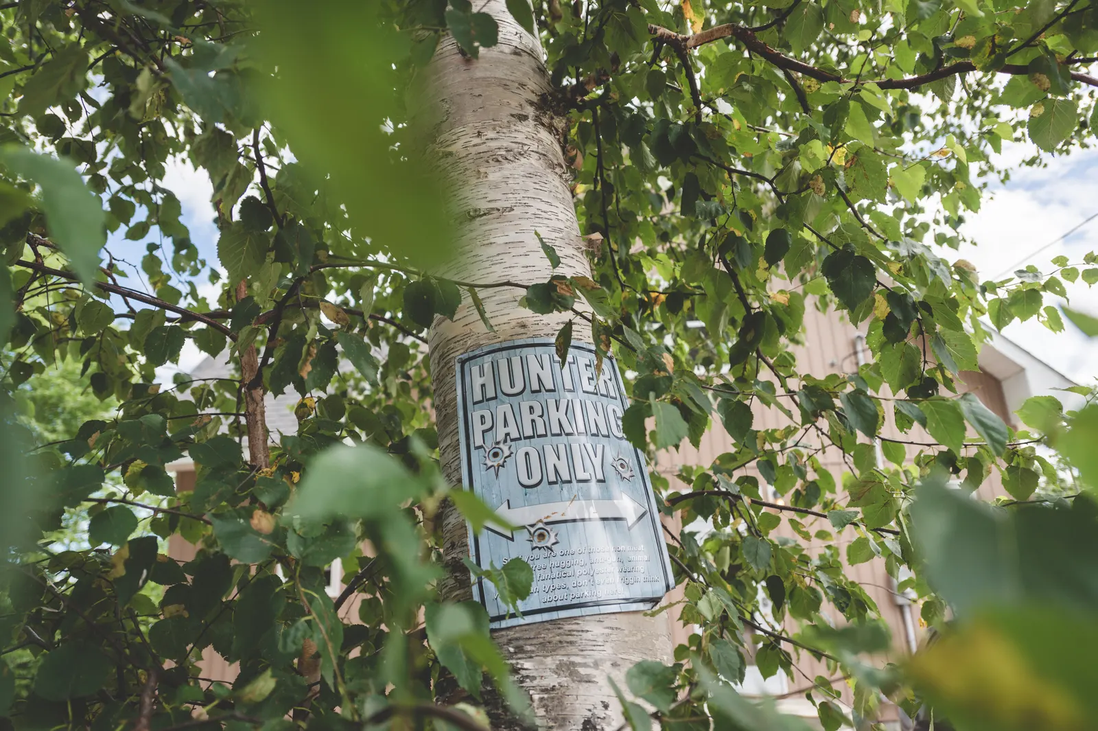A 'Hunter parking only' sign on a tree by the chalet