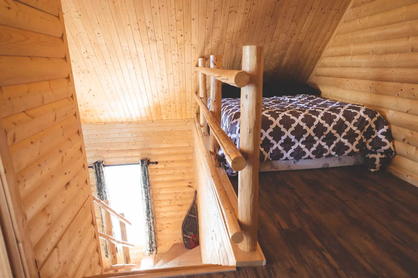The loft, with a bed behind the log railing
