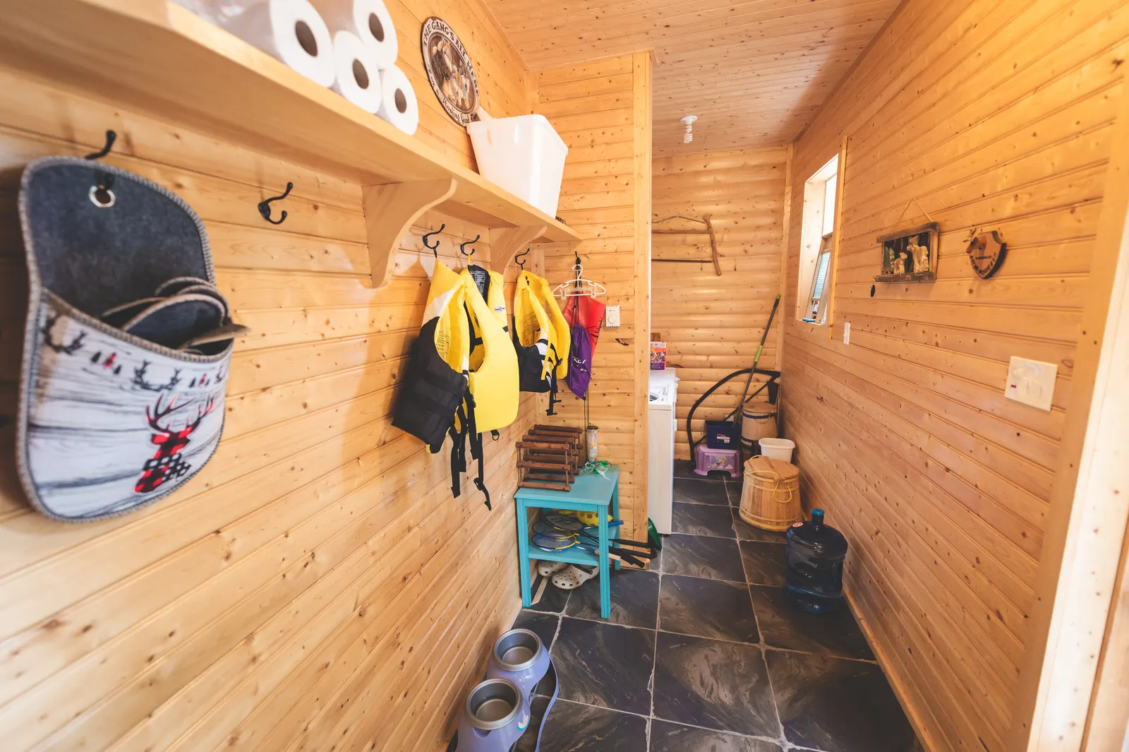 The mudroom by the door, with life jackets on the hooks