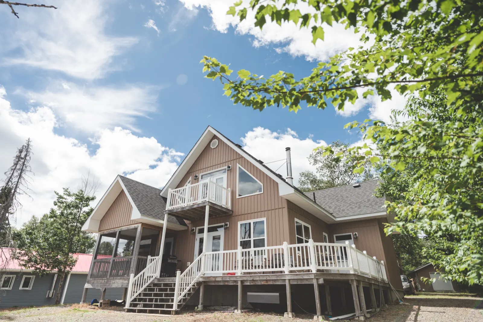 The Hideaway Chalet among the trees, with its wraparound deck and balcony